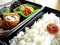 Un makunouchi, un tipo de bentō japonés. A la dreta es veu un Hinomaru bentō, molt popular durant l'imperialisme de Japó. Consistix d'un llit de gohan —arròs blanc cuit al vapor— en un umeboshi en el centre.